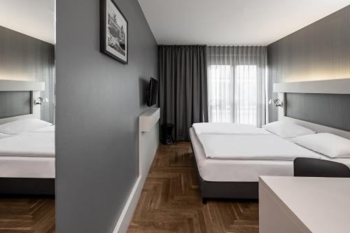 a hotel room with two beds and a window at Hotel AMANO Rooms & Apartments in Berlin
