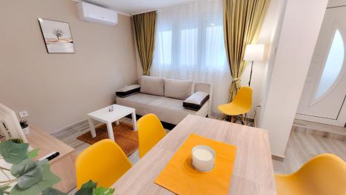 a living room with a table and yellow chairs at Vila Nikola in Soko Banja