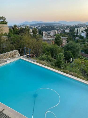 une grande piscine bleue avec vue sur la ville dans l'établissement Villa Riviera, au Cannet