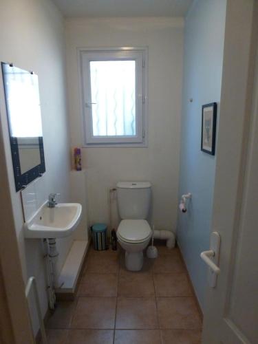 une salle de bain avec toilettes, lavabo et fenêtre dans l'établissement Villa Riviera, au Cannet