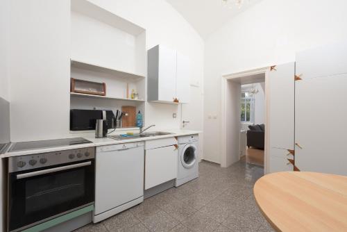 a white kitchen with a stove and a dishwasher at Spacious APT in Perfect Location for Family 24h Check-in in Vienna