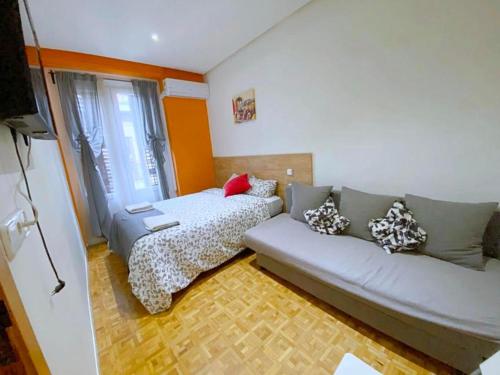 salon z kanapą i łóżkiem w obiekcie Apartamentos TravelStep La Latina w Madrycie