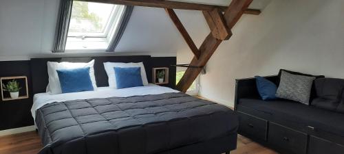 una camera con un grande letto e un divano di vakantieboerderij Aardenhof a Sevenum