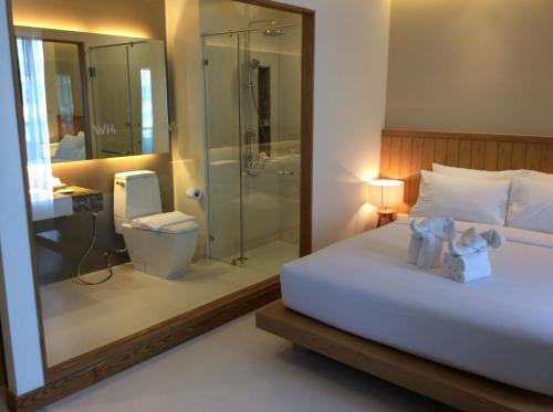 a bedroom with a bed and a shower and a toilet at W14 Pattaya in Pattaya South