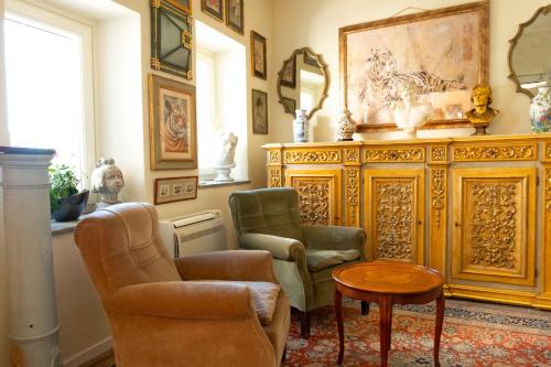 a living room with two chairs and a table at Ai Leoni Ruggenti - Giardino Segreto con Vista sul Monferrato in Ottiglio