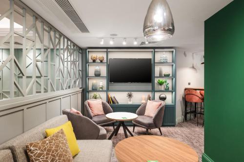 a living room with a couch and chairs and a tv at Holiday Inn Reading West by IHG in Reading