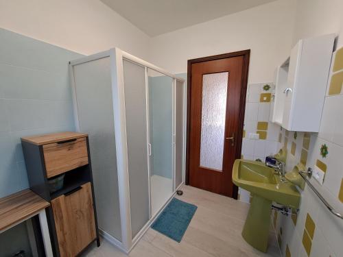 y baño con lavabo verde y ducha. en Casa Vacanze Kristina, en Brissago Valtravaglia