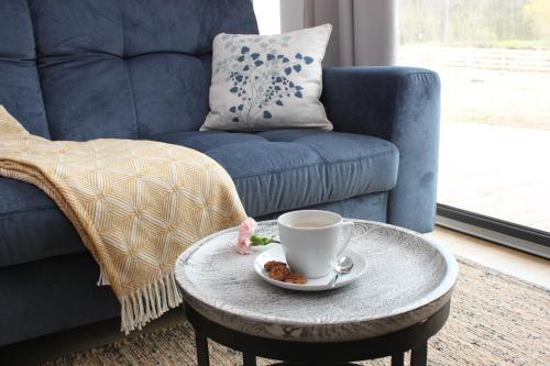 a coffee table with a cup of coffee and a chair at Galena i Gnejs in Stronie Śląskie