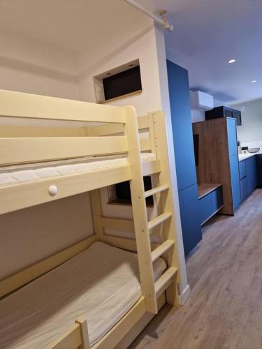 Ce lit superposé se trouve dans un dortoir doté d'un escalier. dans l'établissement CAP CORNICHE - Agréable Studio bord mer, à Sète