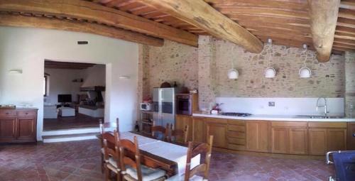 a large kitchen with wooden cabinets and a table at Il Fienile Sotto L'Arco in Tavarnelle Val di Pesa