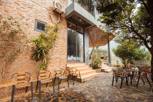 a patio with chairs and tables and a brick building at 1992 Tam Đảo - Venuestay in Tam Ðảo