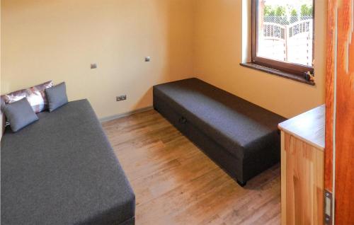 ein Wohnzimmer mit einem Sofa und einem Fenster in der Unterkunft Pet Friendly Apartment In Glowczyce With Kitchen in Główczyce