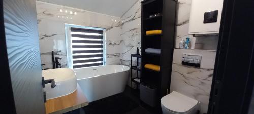 a bathroom with a tub and a toilet and a sink at AirPortOne in Vecsés