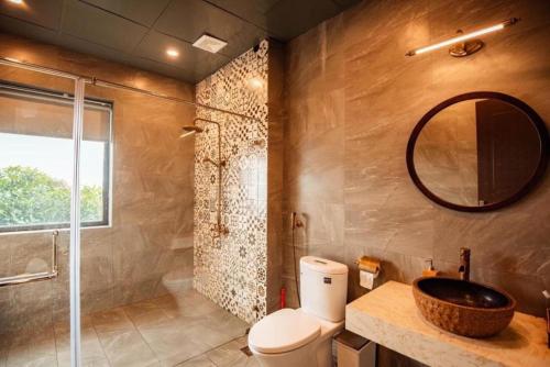a bathroom with a toilet and a sink and a mirror at 1992 Tam Đảo - Venuestay in Tam Ðảo