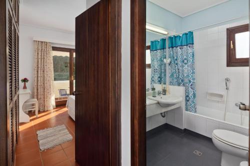 a bathroom with a sink and a toilet and a tub at Villa Lianolia in Perítheia