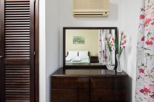 a mirror on a dresser next to a bedroom at Villa Lianolia in Perítheia