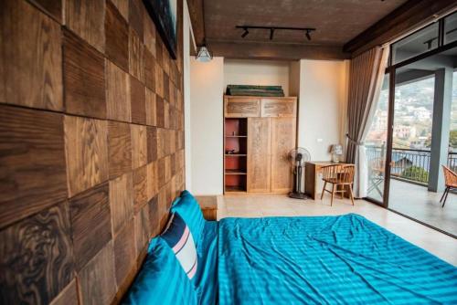 a bedroom with a blue bed and a wooden wall at 1992 Tam Đảo - Venuestay in Tam Ðảo