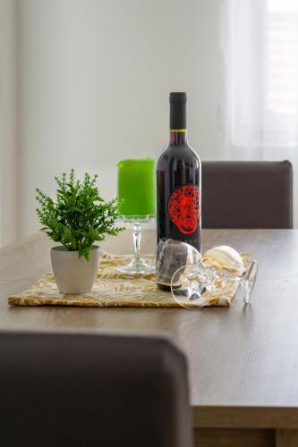 a bottle of wine sitting on top of a table at Apartment Pemper - Self check in and check out in Otočac