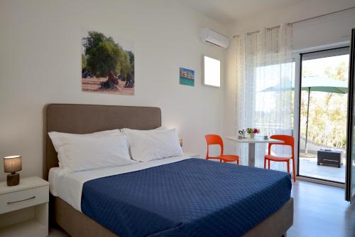 a bedroom with a bed and a table and chairs at Camera & Caffè - Accoglienza Salentina in Villaggio Resta