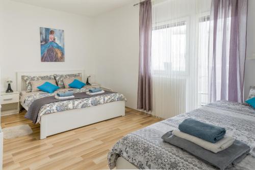 um quarto com 2 camas e uma janela em Apartment Pemper - Self check in and check out em Otočac