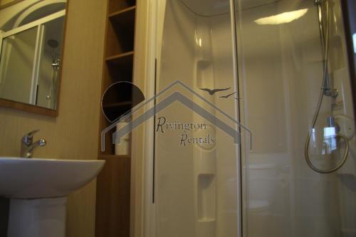 a bathroom with a shower with a sign on the door at Tranquility - Static Caravan Lune Park on Parkdean Ocean Edge Resort in Heysham