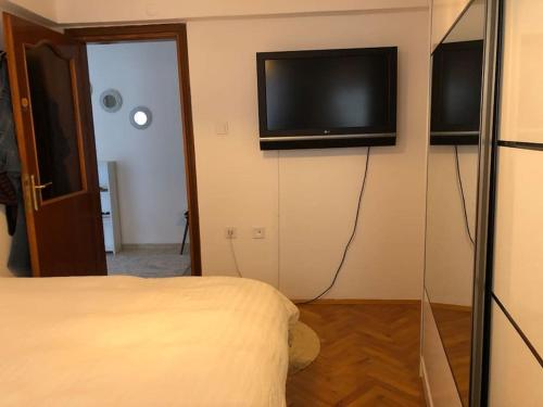 een slaapkamer met een bed en een televisie aan de muur bij In the city center (800m from Cevahir shopping) in Istanbul