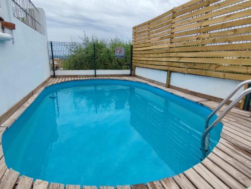 einen Pool auf einer Terrasse mit einem Holzzaun in der Unterkunft Son MASSANET, con piscina y fantásticas vistas in Campanet