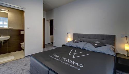 a hotel room with a bed and a bathroom at Vila Vyšehrad in Český Krumlov
