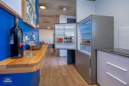 a kitchen with a bottle of wine and a refrigerator at הרימון- צימר בוטיק לזוג במעלה גמלא in Ma'ale Gamla
