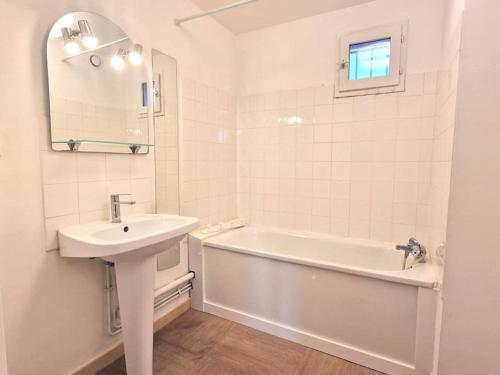 y baño blanco con lavabo y bañera. en Spacious 3-bedroom apartment with terrace and AC in the city centre, en Aviñón