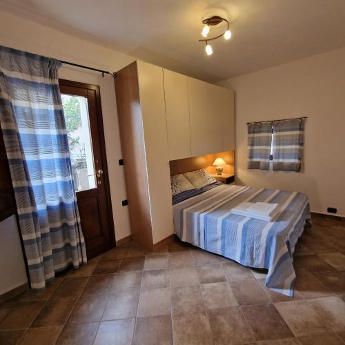 a bedroom with a bed and a window at Ambrosia casa vacanza " Giada " in Orosei