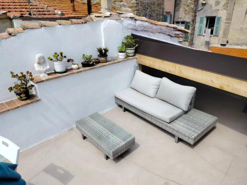 una silla y un banco en un balcón en Attico romantico con terrazza Sanremo - Palm Street, 104, en San Remo