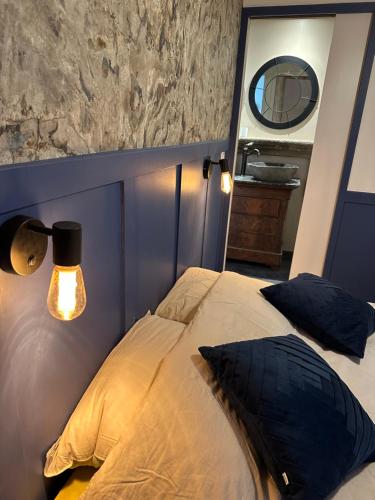 a bedroom with a bed with a lamp and a mirror at Gîte de charme, Le Terrier in Besse-et-Saint-Anastaise