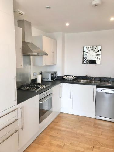 a kitchen with white cabinets and stainless steel appliances at Town & Quiet - 1 Bed - Fast Fibre - Free Parking in Bedford