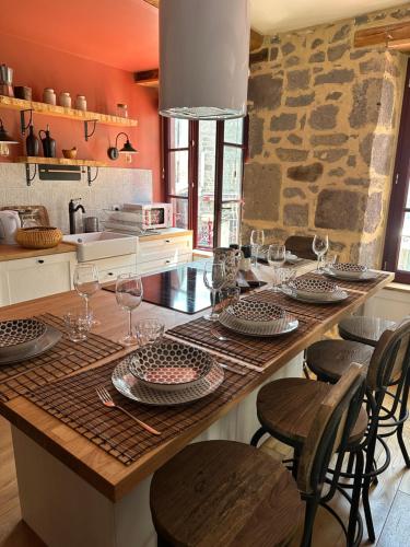 a kitchen with a table with wine glasses on it at Gîte de charme, Le Terrier in Besse-et-Saint-Anastaise