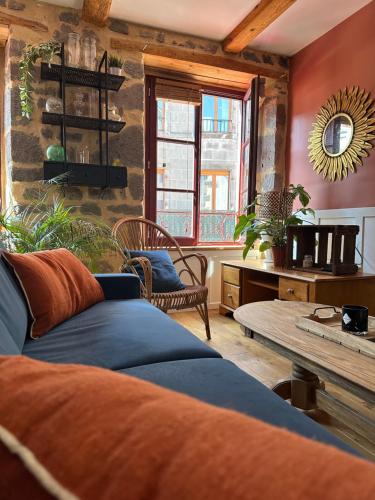 a living room with a couch and a table at Gîte de charme, Le Terrier in Besse-et-Saint-Anastaise