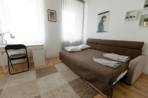 a bedroom with a bed and a chair in it at Hidden Peak Guestrooms in Warsaw