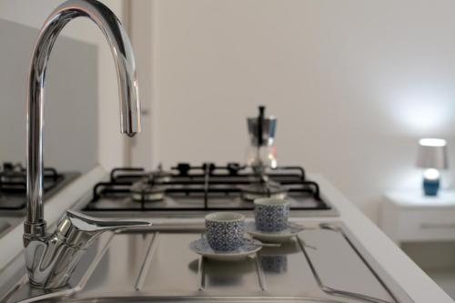 un lavello con due tazze e un piano cottura di Camera & Caffè - Accoglienza Salentina a Villaggio Resta
