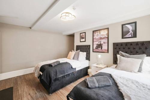 een slaapkamer met 2 bedden en een stoel. bij Chic & Contemporary Apartment with Patio - Parking in Wakefield