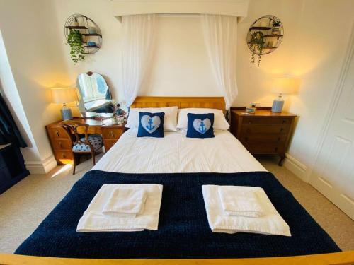 a bedroom with a bed with two pillows on it at Sandy Shores, 3 min walk to beach & Swanage centre in Ulwell