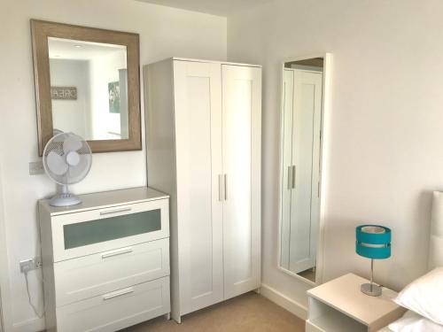 a bedroom with a white dresser and a mirror at Town & Quiet - 1 Bed - Fast Fibre - Free Parking in Bedford