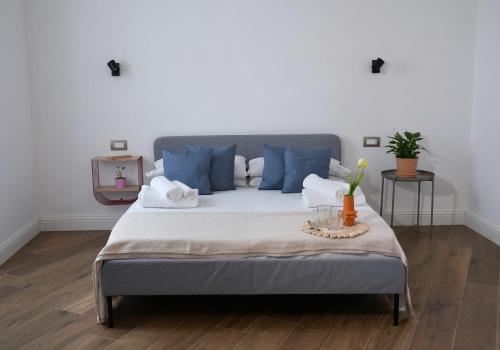 een slaapkamer met een groot bed met blauwe kussens bij Vaaz Rooms in Sannicandro di Bari