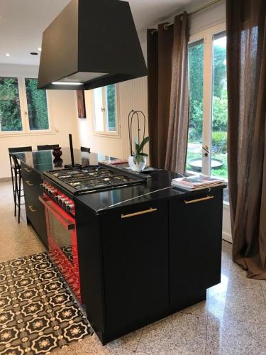 - une cuisine avec un comptoir noir et une cuisinière dans l'établissement Villa Garden - Disneyland Paris, à Montévrain