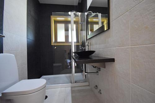a bathroom with a toilet and a sink and a mirror at Casa de Ryvyo in Penafiel
