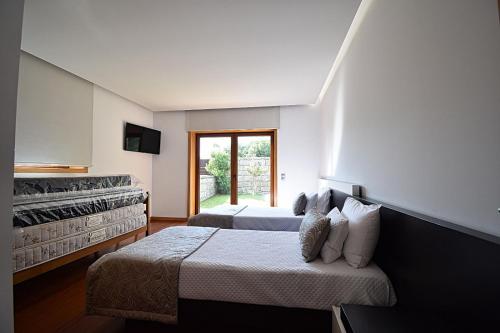 um quarto com 2 camas e uma grande janela em Casa de Ryvyo em Penafiel