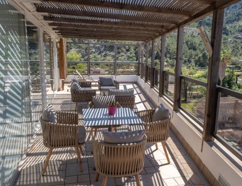 a patio with tables and chairs and windows at Los Geranios in Port de Soller