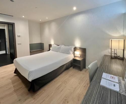 Un dormitorio con una gran cama blanca y una lámpara en HelloSky Air Rooms Madrid, en Madrid