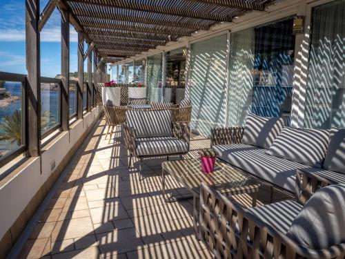 a porch with chairs and tables on a balcony at Los Geranios in Port de Soller