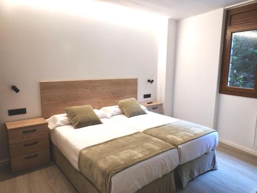 Un dormitorio con una cama grande y una ventana en Apartaments Turistics El Buner, en Ordino