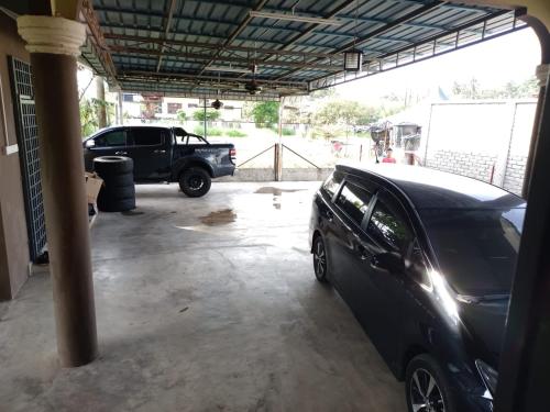 um carro preto estacionado dentro de uma garagem em D Embun Homestay em Pasir Mas